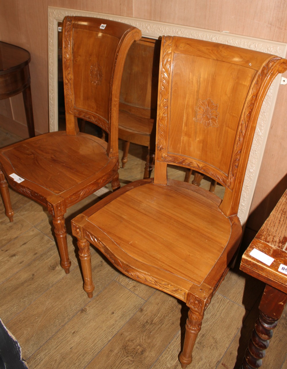A pair of Asian hardwood hall chairs, with foliate carved frames, W.57cm D.52cm H.115cm